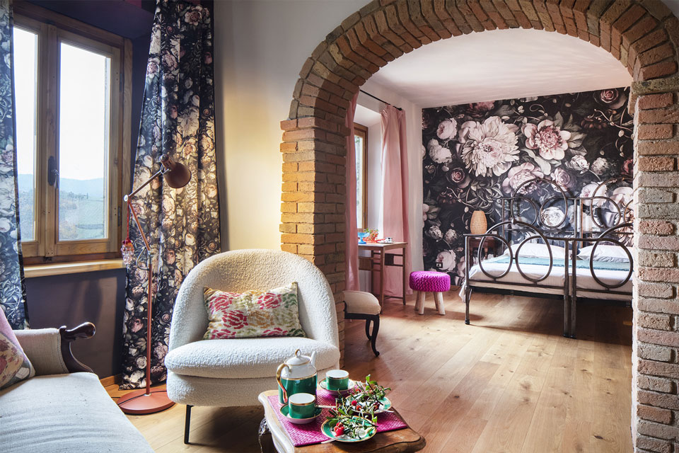 Ispirata a una donna che non passava inosservata, questa camera è un’esplosione floreale dal carattere audace. Il letto in ferro, il divano d’epoca e i dettagli di design contemporaneo creano un insieme scenografico, grandioso e indimenticabile.